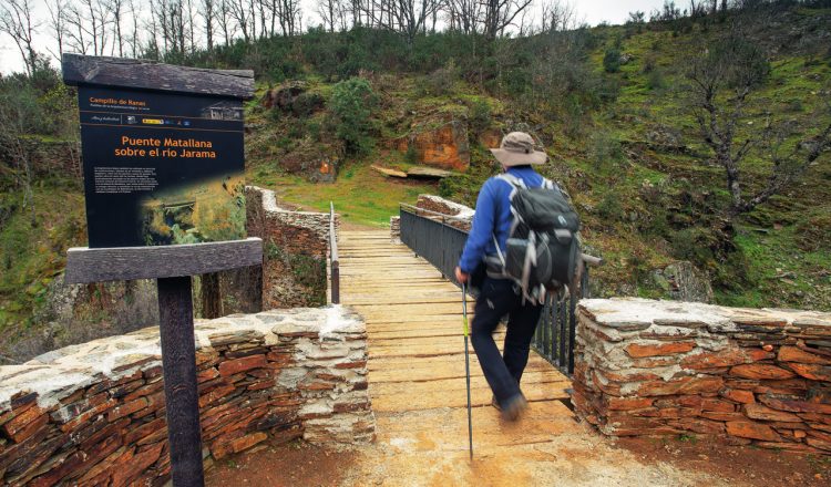 Un excursionista cruza el puente Matallana más conocido como puente de los Trillos