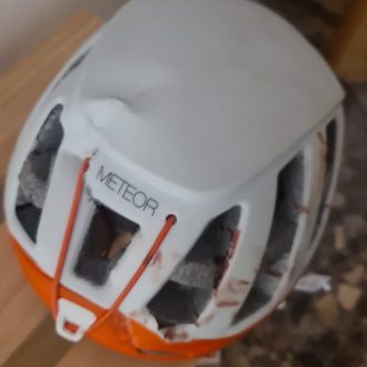 Casco tras el impacto de una piedra por el compañero de cordada