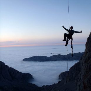 Rapelando ante un mar de nubes durante la escalada a "Sueños de invierno" en el Naranjo de Bulnes  (Col. Hnos. Cano)